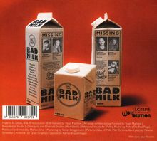 Mehrere Milchpackungen mit der Aufschrift „BAD MILK“ und vermissten Anzeigen. Hintergrund in leuchtendem Orange.