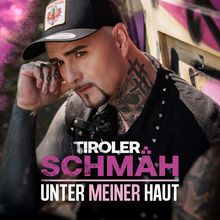 „Tiroler Schmäh: Unter meiner Haut“. Ein Mann mit Tattoos und Mütze lehnt an einer Wand mit Graffiti.