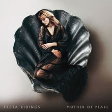 "FREYA RIDINGS, MOTHER OF PEARL" steht unten. Eine Frau in schwarzem Kleid sitzt in einer Muschelschale.