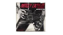 "Mötley Crüe: Too Fast for Love" in roter Schrift, eine Hand in schwarzer Lederkleidung mit Nieten und Gürtelschnalle.