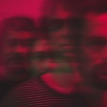 Verschwommene Gesichter in roten und schwarzen Tönen, horizontal verzerrt. Kontrastreich und abstrakt.
