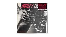 "Mötley Crüe", "Too Fast for Love", Leder mit Nieten; Hände mit Ringen und Armbändern.