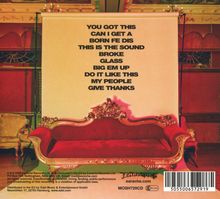 Ein rotes, antikes Sofa vor einer Leinwand mit großen schwarzen Buchstaben auf englisch: "YOU GOT THIS ... GIVE THANKS".