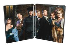 Eine Gruppe elegant gekleideter Menschen posiert, einige tragen Hüte und Abendkleidung.