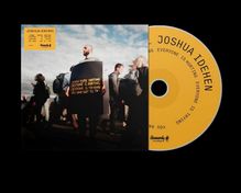 JOSHUA IDEHEN, "I KNOW YOU'RE HURTING", Mann mit Schild, Personen im Freien, gelbe CD rechts.