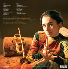 Texte: Songtitel und Künstlerliste. Eine Frau sitzt auf einem Sofa, trägt ein buntes Kleid, im Hintergrund eine Trompete.