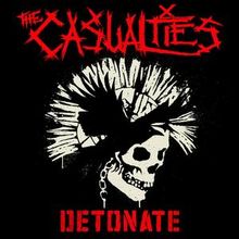 "The Casualties" und "Detonate" in roter Schrift. Darunter ein Totenkopf mit Irokesenschnitt, schwarz-weiß.