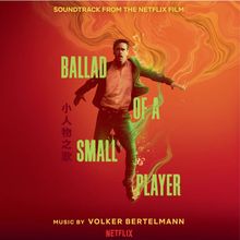 „Ballad of a Small Player“, „Volker Bertelmann“, „Netflix“. Ein Mann schwebt im roten Wirbel aus Rauch und Licht.