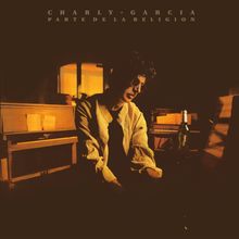 "CHARLY GARCIA PARTE DE LA RELIGION" in gelber Schrift über einem Mann an einem Klavier, neben einer Flasche.