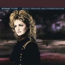 "BONNIE TYLER · SECRET DREAMS AND FORBIDDEN FIRE". Frau mit lockigem Haar im Porträt, düsterer Himmel im Hintergrund.