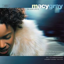 „macy gray, ON HOW LIFE IS“ in großen Buchstaben oben. Eine Person mit lockigem Haar und Felljacke näht die Augen.