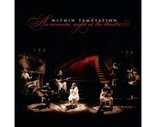 „Within Temptation: An acoustic night at the theatre“. Musiker in Theateratmosphäre, warme Beleuchtung, rote Treppe im Hintergrund.