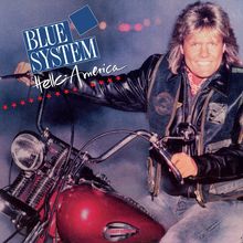 "Blue System" und "Hello America" in weißer Schrift. Person mit Lederjacke auf einem roten Motorrad, lächelnd.