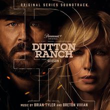 Texte: "Original Series Soundtrack", "Paramount+", "Original", "Dutton Ranch Season 1", "Music by Brian Tyler and Breton Vivian". Zwei Gesichter im Hintergrund, geteilt durch Buchstaben.