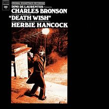 Text oben: "CHARLES BRONSON", "DEATH WISH", "HERBIE HANCOCK". Illustration eines Mannes mit Pistole unter Straßenlaterne.