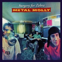 "Surgery for Zebra, Metal Molly." Drei Personen in einem Raum, eine mit Gasmaske, eine sitzend mit Zeitung, eine trägt eine Mütze.