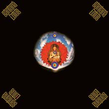 Text: "santana lotus" in goldener Schrift an den Ecken. Buddha-Figur auf roter Blume, umgeben von blauem Himmel und Regenbogenkreisen.