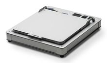 Flacher, silberner elektronischer Gerät mit Ecken, Schalter und Anschlüssen oben; schlichtes, modernes Design.