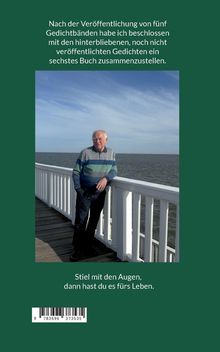Ein älterer Mann lehnt an einem weißen Geländer an einem Holzsteg am Meer.