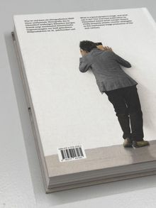 Texte beschreiben künstlerische Bildproduktion. Eine Person lehnt sich an die Wand und betrachtet etwas intensiv.