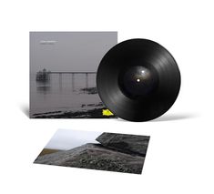 Ein schwarzes Vinyl, Albumcover mit Brückenmotiv, und ein Landschaftsfoto.