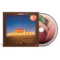 Text: „PEACHES!“ und „Coca-Cola“. Oben steht „THE BLACK KEYS“. Ein altes Reklameschild auf Wellblechdach, Stromleitungen im Hintergrund.