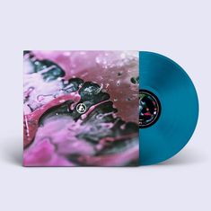 Ein stilisiertes Logo auf pinker, abstrakter Oberfläche neben einer blauen Vinyl-Schallplatte.