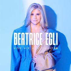 Text: "BEATRICE EGLI", "HÖR NIE AUF DAMIT 2.0". Frau mit blonden Haaren trägt einen offenen Mantel, blau beleuchteter Hintergrund.