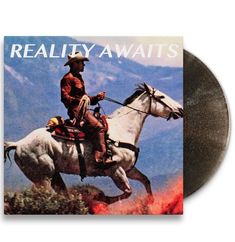Text: "REALITY AWAITS". Ein Cowboy reitet auf einem weißen Pferd durch eine feurige Landschaft.