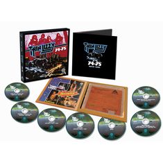 „Thin Lizzy 74-75“ steht auf einer Box und einer Broschüre. Einige CDs und Plattencover mit Bildern sind daneben angeordnet.