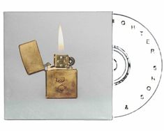 Text: "PZF". Ein offenes Metal-Feuerzeug mit Flamme. Daneben eine CD mit unleserlichen Textfragmenten.