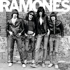 "RAMONES" steht in großen Buchstaben oben. Darunter vier Männer in Lederjacken und Jeans, vor einer Backsteinmauer.