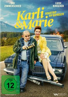 „Karli & Marie: Roadtrip auf Bayrisch“ steht in gelber Schrift. Ein Mann und eine Frau sitzen auf einem Auto.