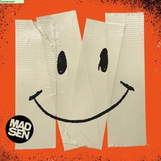 „Madsen“ in weißem Text auf schwarzem Kreis. Beklebtes Smile-Gesicht auf orangefarbenem Hintergrund.