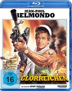 Text: "JEAN-PAUL BELMONDO", "DIE GLORREICHEN", "FSK ab 16 freigegeben", "EIN FILM VON HENRI VERNEUIL".<br>Illustration: Mann mit Waffe vor Rauch und Fahrzeugen.