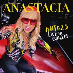 "ANASTACIA", "#NTK25 LIVE IN CONCERT". Eine Frau mit roter Brille und buntem, mit Nieten besetztem Jackett.
