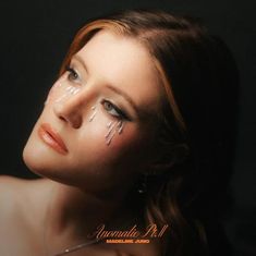 Text: "Anomalie Pt. II, Madeline Juno". Frau mit glitzernden Tränenverzierungen schaut nachdenklich zur Seite.