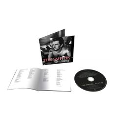 "The Smiths ...Best II" steht in rosa und weißem Text. Es zeigt einen Mann mit Tattoos, der an einem Tisch sitzt.