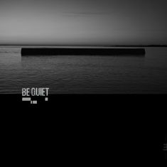 Text: „BE QUIET“, „NILS PETTER MOLVÆR“, schwarz-weißes CD-Cover mit dunkler Wasseroberfläche, CD teilweise sichtbar.