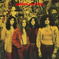 „Golden Earring“ steht oben in roter Schrift. Vier Männer mit langen Haaren stehen vor einer Wand voller Puppen.