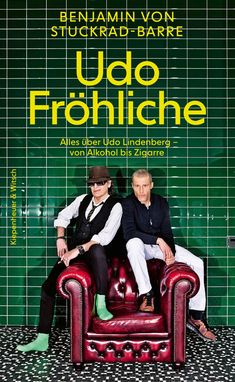 "Udo Fröhliche" von Benjamin von Stuckrad-Barre. Zwei Männer sitzen auf einem roten Ledersofa vor grünen Kacheln.