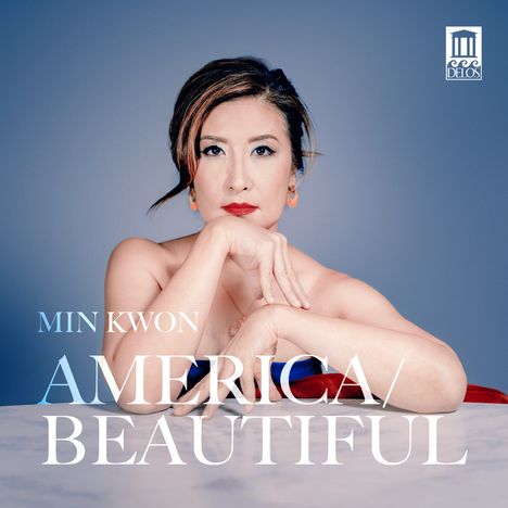 Texte: "Min Kwon America/Beautiful". Eine Frau schaut ernst, Kinn auf Hände gestützt, vor blauem Hintergrund. Logo oben rechts.