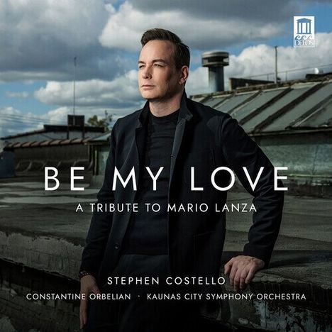 "BE MY LOVE: A Tribute to Mario Lanza" steht auf einem Foto eines Mannes in formeller Kleidung auf einem Dach.