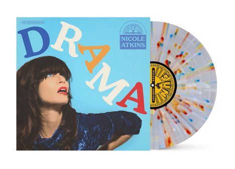 „DRAMA“ und „NICOLE ATKINS“ in bunten Buchstaben. Frau mit dunklem Haar und rotem Lippenstift. Bunte Vinyl-Schallplatte.