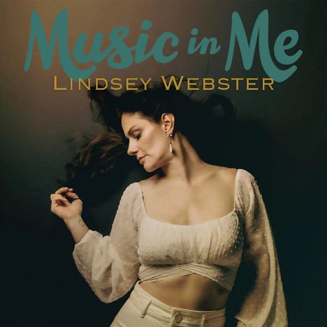 "Music in Me, Lindsey Webster." Eine Frau mit geschlossenen Augen, in eleganter Pose und hellbeigem Outfit.