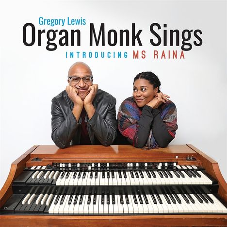 „Gregory Lewis Organ Monk Sings Introducing Ms Raina“; Zwei Personen lehnen an einer Hammond-Orgel und lächeln freundlich.