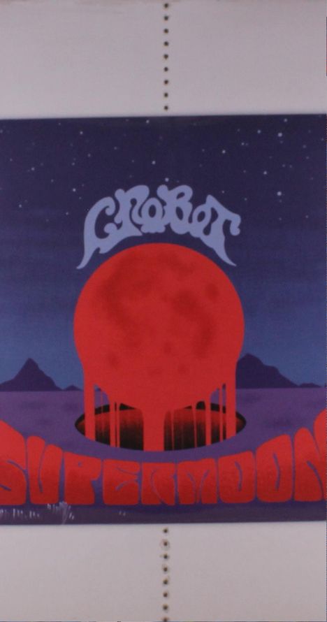 Text: "GROOB" oben, "SUPERM" unten. Illustration einer großen roten Kugel vor Sternenhimmel und Bergen.