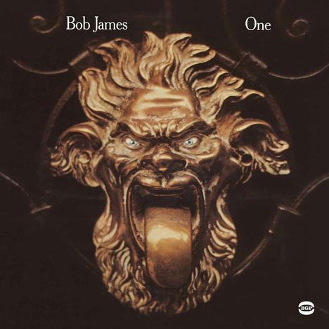 "Bob James" und "One" in Weiß. Ein kunstvoll gestalteter, brüllender Löwenkopf aus Metall, detailliert und massiv.