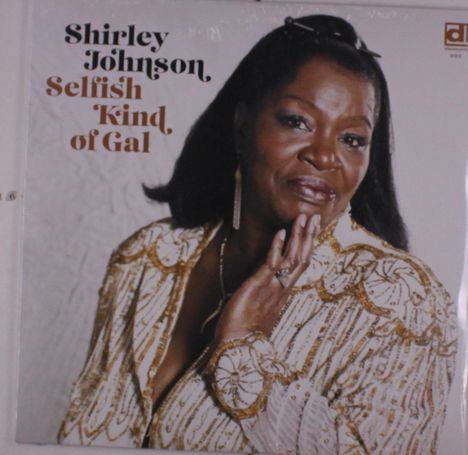Text: "Shirley Johnson, Selfish Kind of Gal." Eine Frau in einem glitzernden Outfit schaut selbstbewusst in die Kamera.