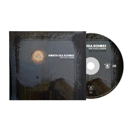 Cover-Text: "NORTH SEA ECHOES – HOW TO CAST A SHADOW". Dunkle, mystische Landschaft mit Mondschein. CD daneben.